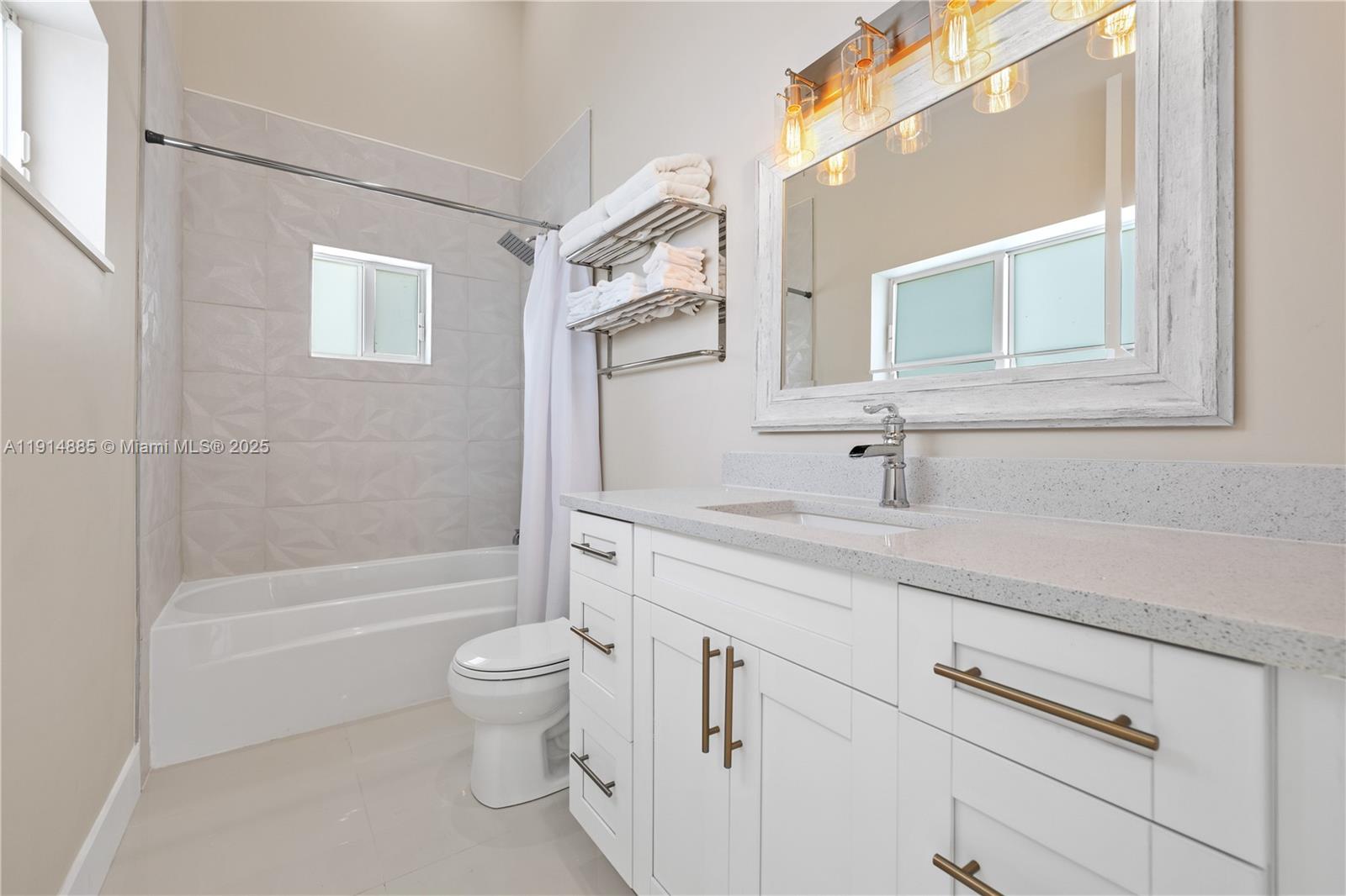 12 Adams Road Ocean Ridge, FL 33435 - Photo 18 of 24 a bathroom with a granite countertop sink a toilet and a bathtub