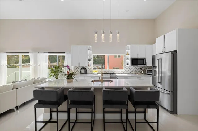 a kitchen with white cabinets and stainless steel appliances