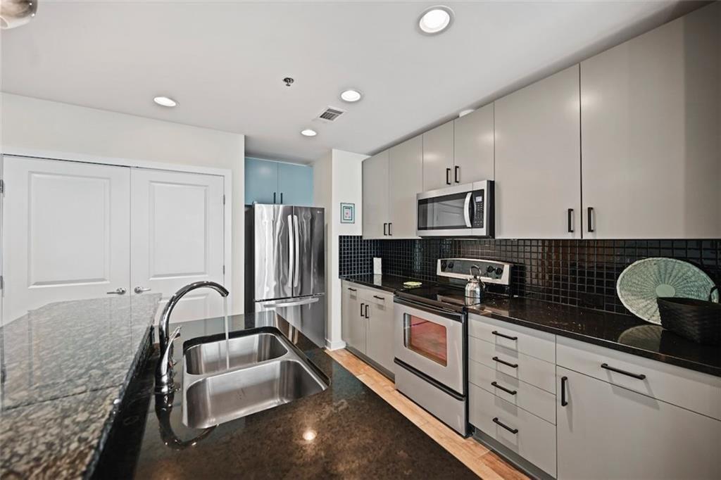 250 Pharr Road Northeast, Unit 602 Atlanta, GA 30305 - Photo 11 of 38 a kitchen with granite countertop a refrigerator stove and sink
