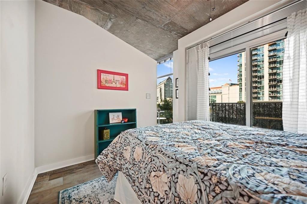 250 Pharr Road Northeast, Unit 602 Atlanta, GA 30305 - Photo 14 of 38 a bedroom with a bed and a large window