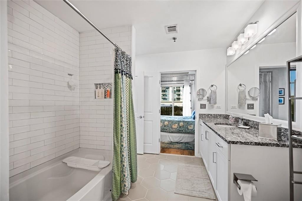 250 Pharr Road Northeast, Unit 602 Atlanta, GA 30305 - Photo 16 of 38 a bathroom with a granite countertop sink a toilet and shower