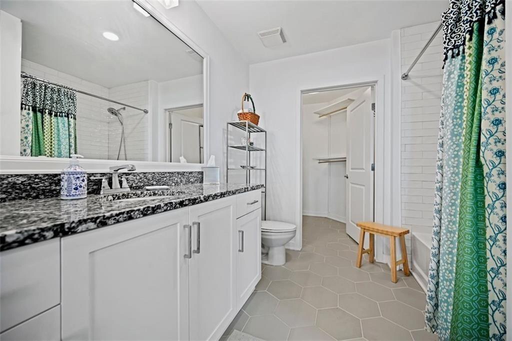 250 Pharr Road Northeast, Unit 602 Atlanta, GA 30305 - Photo 17 of 38 a bathroom with a sink a toilet and a mirror