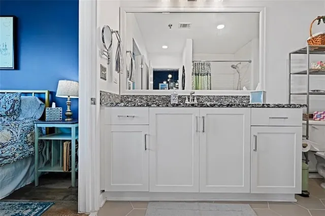 a bathroom with a granite countertop sink and a mirror