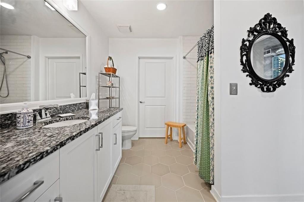 250 Pharr Road Northeast, Unit 602 Atlanta, GA 30305 - Photo 19 of 38 a bathroom with a granite countertop sink and a mirror
