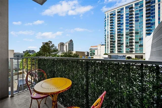 a dining hall with stainless steel appliances kitchen island granite countertop a table chairs and a wooden floor