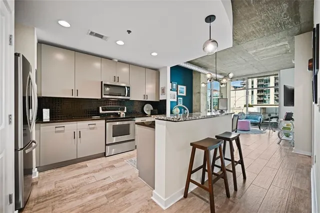 a kitchen with granite countertop a refrigerator stove and sink