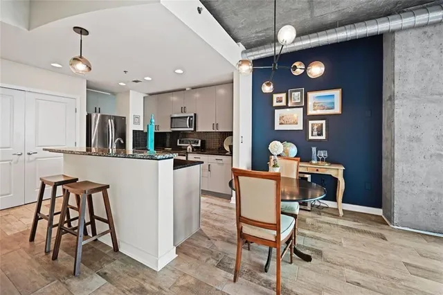 a kitchen with granite countertop a refrigerator stove and sink