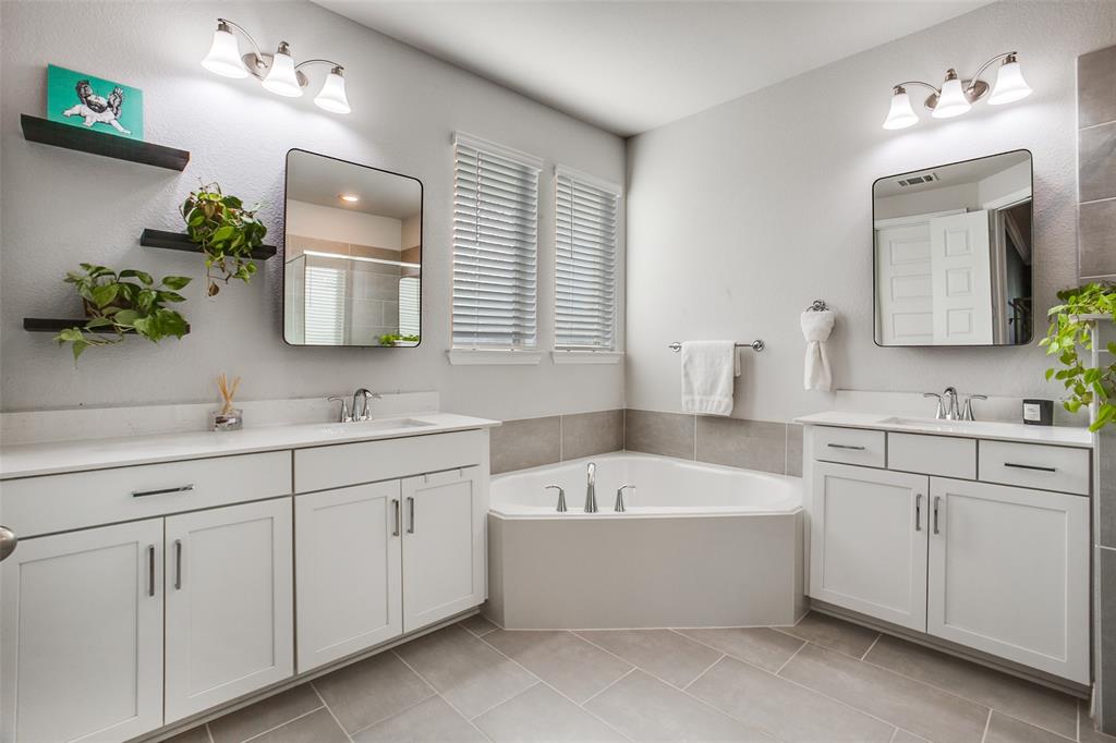 311 Suncrest Way Sunnyvale, TX 75182 - Photo 21 of 40 a bathroom with a tub a sink double vanity and mirror