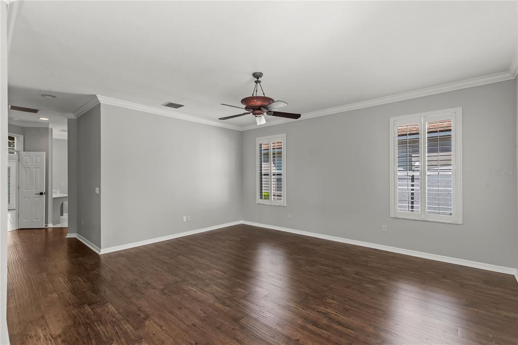 121 Figtree Run Longwood, FL 32750 - Photo 21 of 33 an empty room with wooden floor chandelier fan and windows