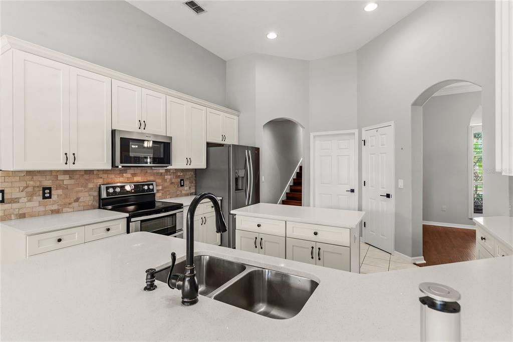 121 Figtree Run Longwood, FL 32750 - Photo 9 of 33 a kitchen with stainless steel appliances a sink a stove a refrigerator and cabinets