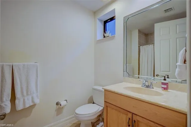 a bathroom with a sink toilet vanity and shower
