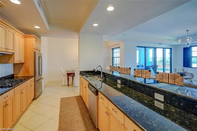 a large kitchen with stainless steel appliances a large counter top a stove and a sink