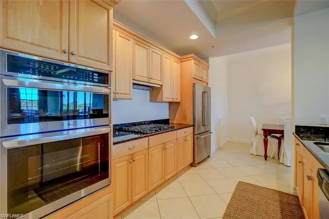 a kitchen with granite countertop a stove and a refrigerator