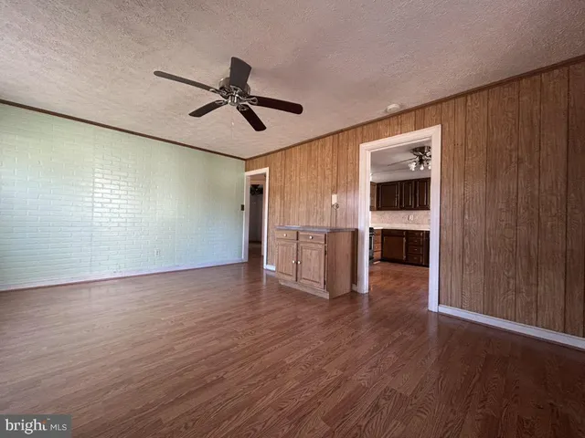 a view of empty room with wooden floor and window