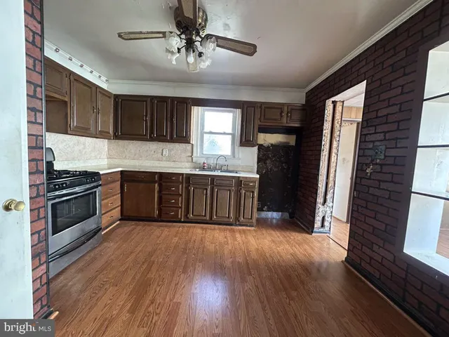 a kitchen with stainless steel appliances granite countertop a refrigerator a sink dishwasher a stove with wooden floors