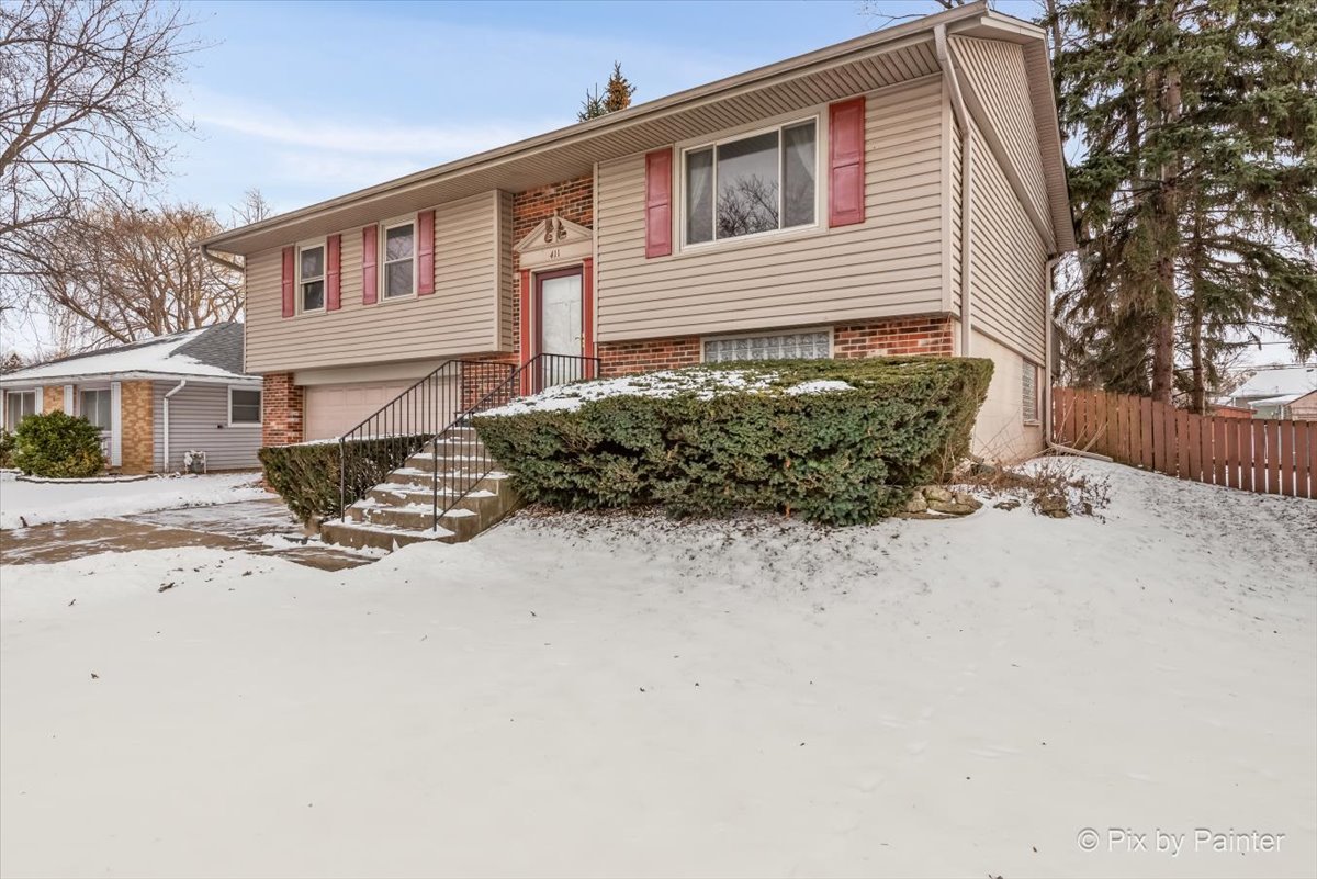 411 Krause Avenue Streamwood, IL 60107 - Photo 42 of 54 a front view of a house with a yard covered in snow