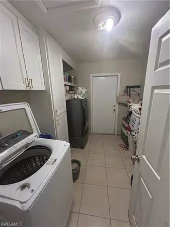 a view of storage and utility room with refrigerator and washer