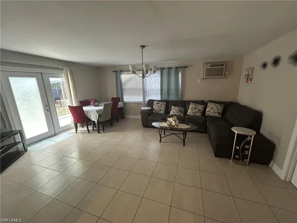 a living room with furniture a flat screen tv and a window