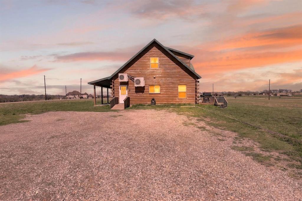131 Hawk Ridge Decatur, TX 76234 - Photo 8 of 34 Back of property at dusk with log siding and a lawn