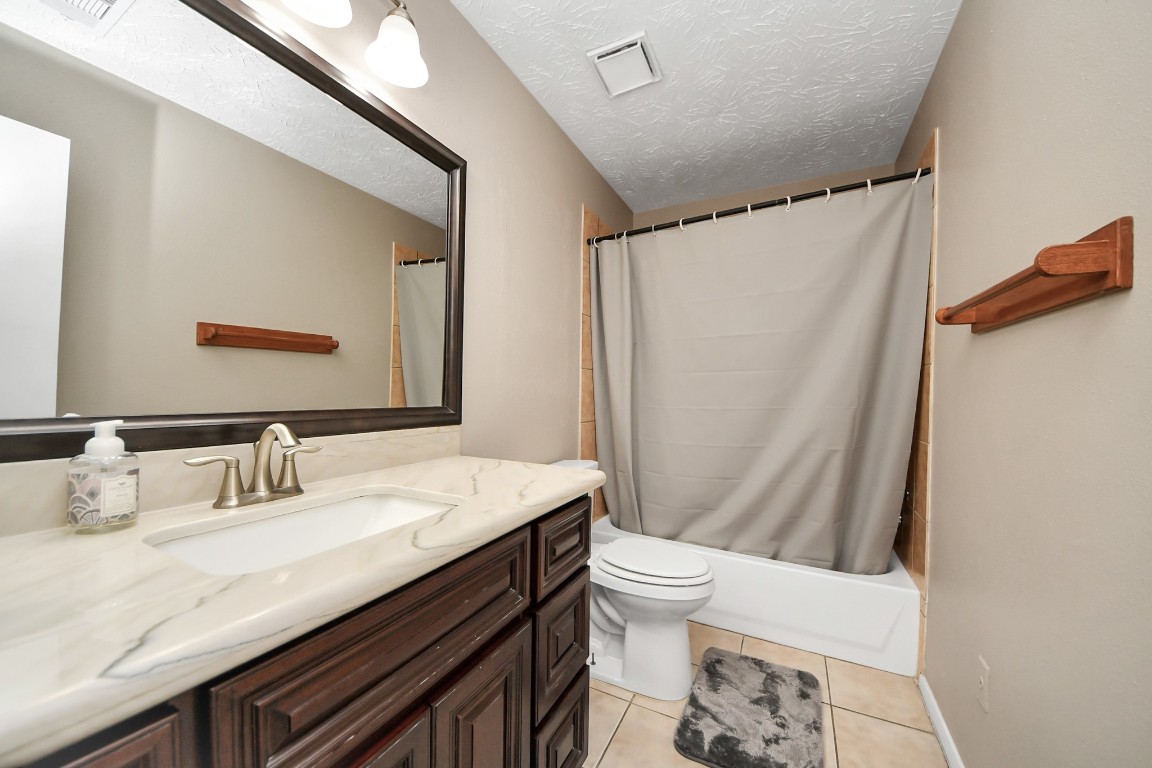 9634 Thistle Trail Drive Houston, TX 77070 - Photo 15 of 22 a bathroom with a granite countertop sink toilet and shower
