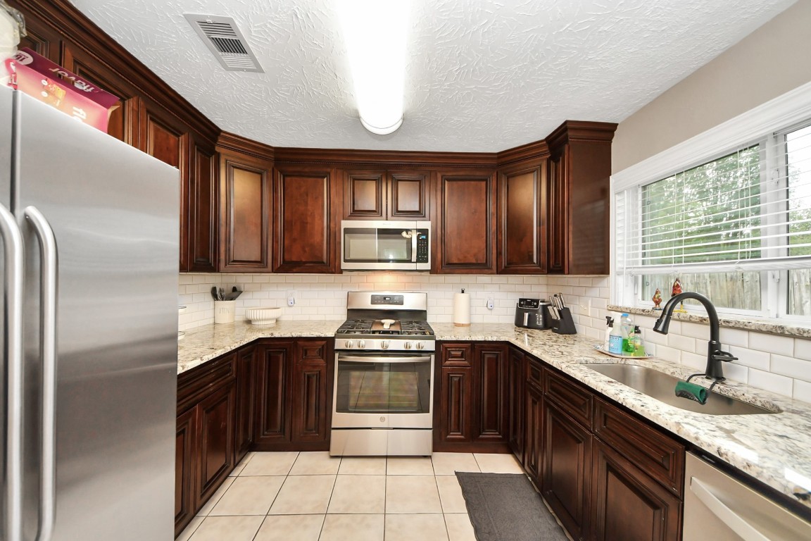 9634 Thistle Trail Drive Houston, TX 77070 - Photo 8 of 22 a kitchen with a sink stove and cabinets