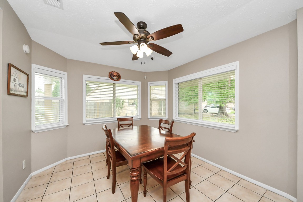 9634 Thistle Trail Drive Houston, TX 77070 - Photo 9 of 22 a dining room with wooden floor and a ceiling fan