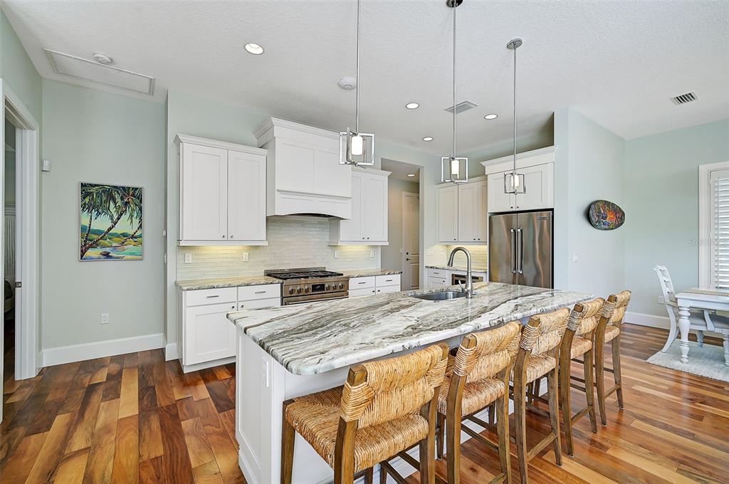 830 Tarawitt Drive Longboat Key, FL 34228 - Photo 13 of 74 a open kitchen with stainless steel appliances granite countertop a stove a refrigerator a kitchen island a sink and a refrigerator