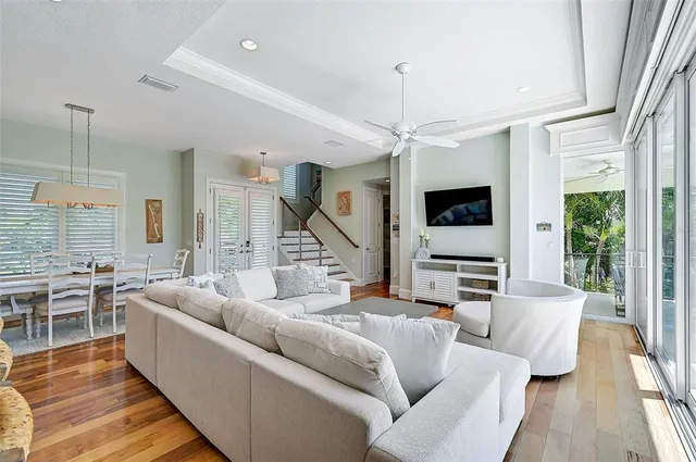 a living room with furniture a large window and a chandelier
