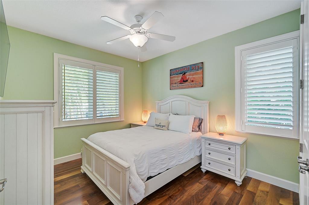 830 Tarawitt Drive Longboat Key, FL 34228 - Photo 28 of 74 a bedroom with a bed and a chandelier