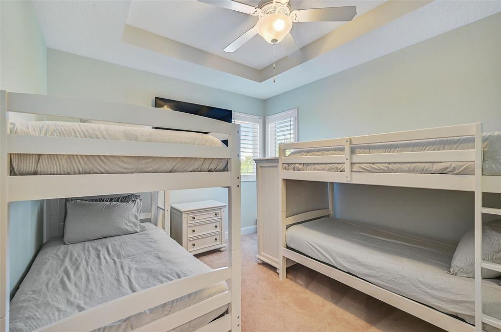 830 Tarawitt Drive Longboat Key, FL 34228 - Photo 35 of 74 a bedroom with a bed and a chandelier