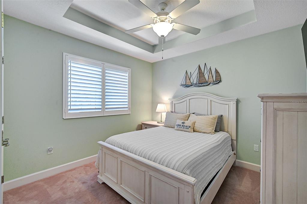 830 Tarawitt Drive Longboat Key, FL 34228 - Photo 37 of 74 a bedroom with a large bed and a chandelier