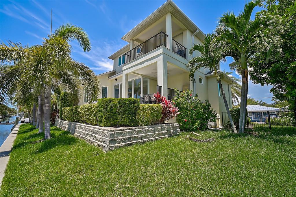 830 Tarawitt Drive Longboat Key, FL 34228 - Photo 57 of 74 a front view of a house with a garden