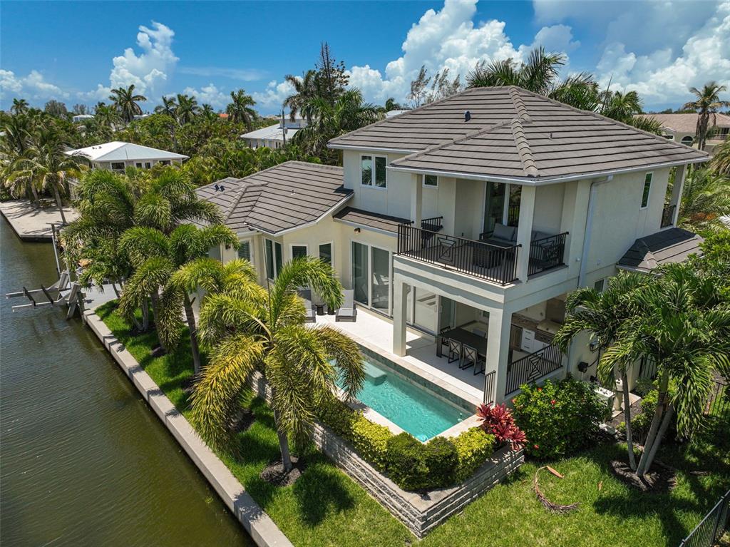 830 Tarawitt Drive Longboat Key, FL 34228 - Photo 62 of 74 a aerial view of a house with swimming pool and a yard