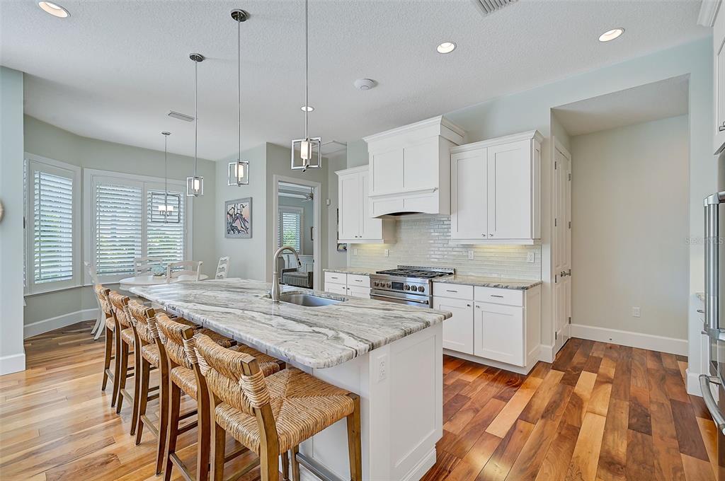 830 Tarawitt Drive Longboat Key, FL 34228 - Photo 8 of 74 a kitchen with stainless steel appliances granite countertop a stove top oven a sink refrigerator and cabinets