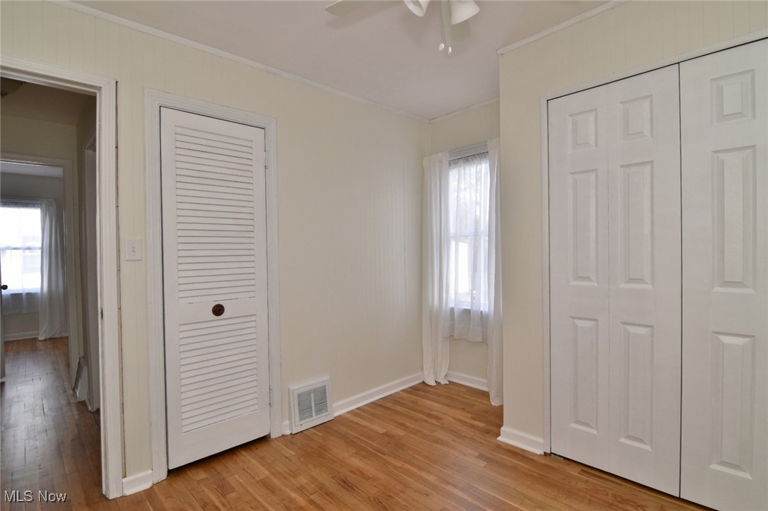 1575 Lander Road Cleveland, OH 44124 - Photo 20 of 49 Unfurnished bedroom with two closets, light wood-style flooring, crown molding, and ceiling fan