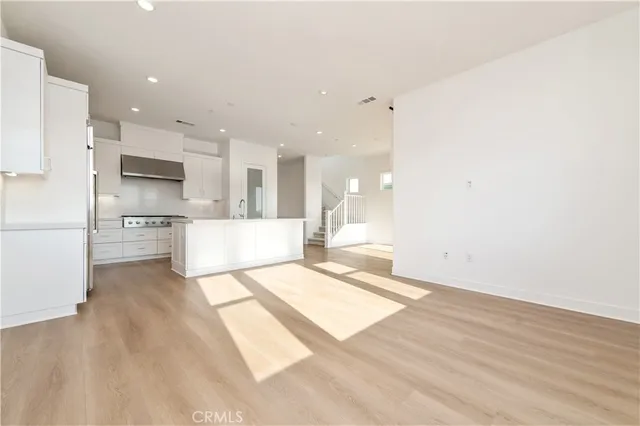 a large white kitchen with a refrigerator a stove and a sink