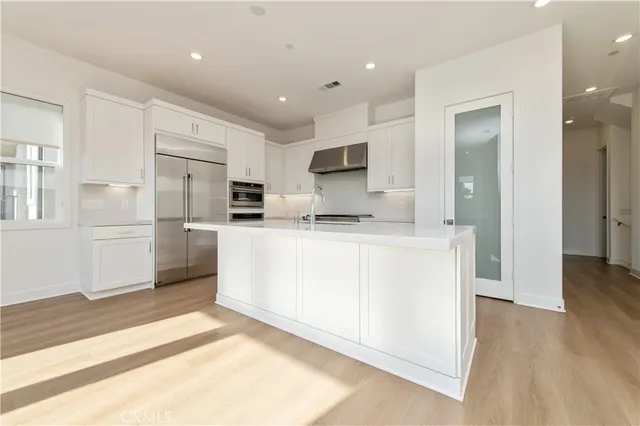 a kitchen with white cabinets and white appliances