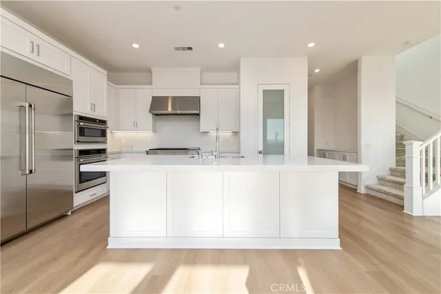 a kitchen with stainless steel appliances granite countertop a refrigerator and a stove