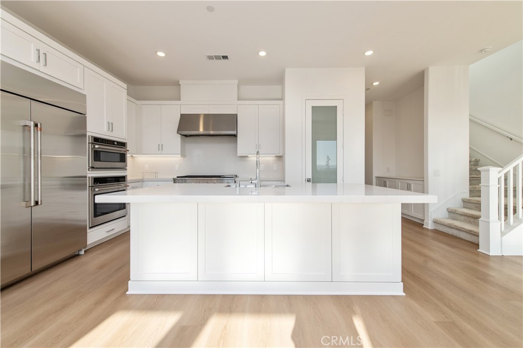 423 Flycatcher Irvine, CA 92618 - Photo 20 of 35 a kitchen with stainless steel appliances granite countertop a refrigerator and a stove