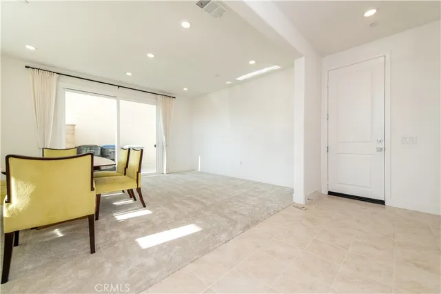 a dining room with furniture and a floor to ceiling window