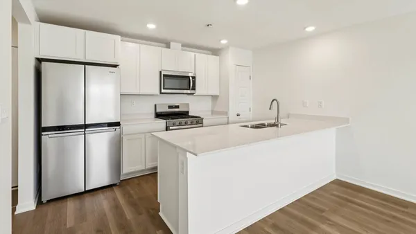 a kitchen with kitchen island a sink stainless steel appliances and refrigerator