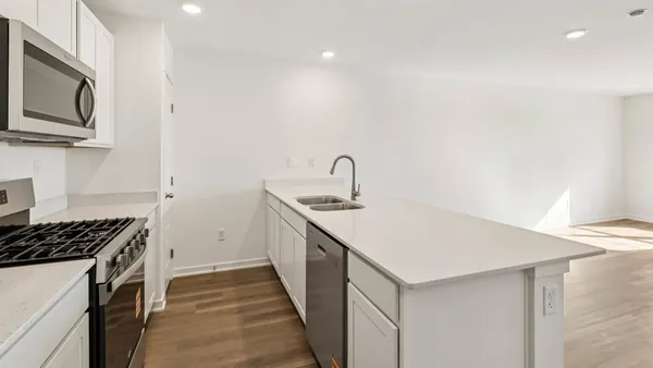 a kitchen that has a sink and a stove top oven