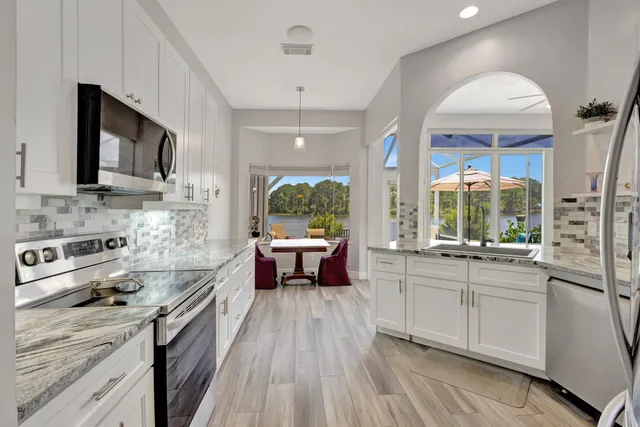 a dining room with furniture a chandelier and wooden floor