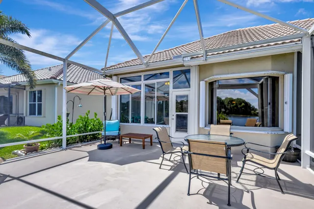 a view of a patio with chairs and table under an umbrella