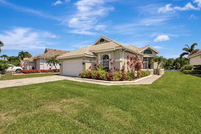 a front view of a house with a garden and plants