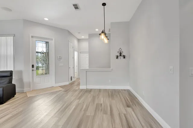 a view of a room with wooden floor staircase and a kitchen space