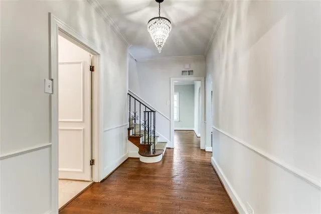 a view of a hallway with wooden floor and staircase