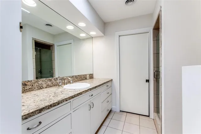 a bathroom with a granite countertop sink and a mirror