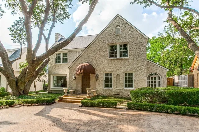 a front view of a house with a yard and potted plants
