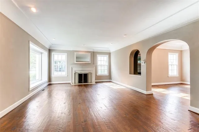 a view of empty room with wooden floor and fireplace
